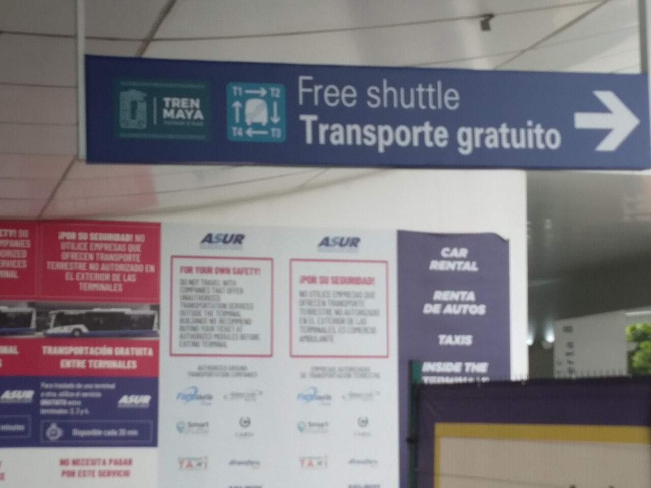 Sign in a Cancun airport terminal pointing to the free shuttle to the Tren Maya station